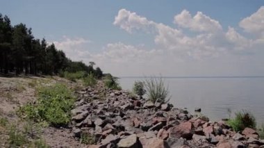 Kayalık nehir kıyısı ve bulutlu mavi gökyüzü
