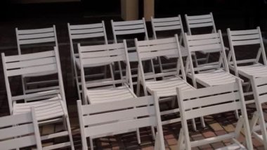 Dışarıda bir toplantıda bir sürü beyaz sandalye.