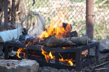 Demir ızgara piknik ateşinde şenlik ateşi yanıyor.