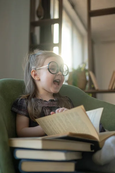 Маленькая милая девочка в очках читает книги. назад в школу — стоковое фото