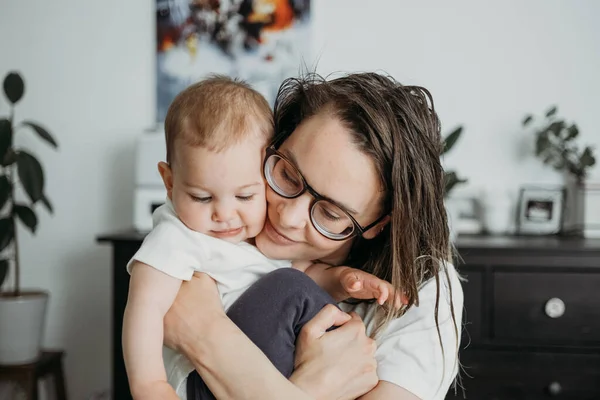 Mother playing with her little baby at home lifestyle concept look. Neutral white clothes clothes, gender neutral colours — Stock Photo, Image