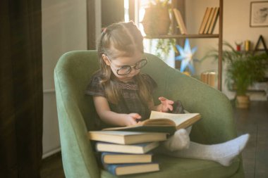 Gözlüklü küçük şirin kız kitap okuyor. Okula geri dön.