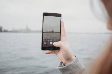 Akıllı telefonun kapanışı Sant-Petersburg 'daki güzel turistik manzaranın fotoğrafını çekiyor. 