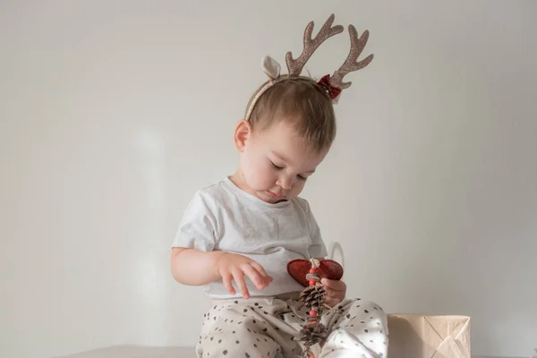 Parlak parlak yağmurlu geyik boynuzları kostümlü küçük kız. Yeni yıl ve noel partisi kutlaması. Noel tatili.
