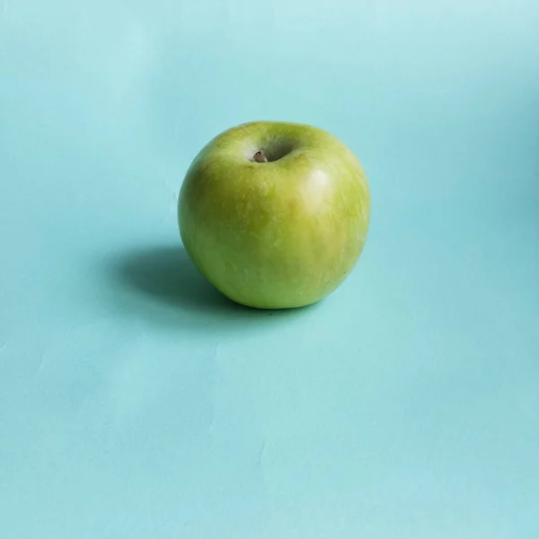 One Green apple lying on blue background — Stock Photo, Image