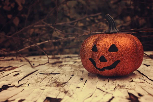 Ragyogó halloweeni tök a faasztalon. ősz szezonális kísérteties dekoráció — Stock Fotó