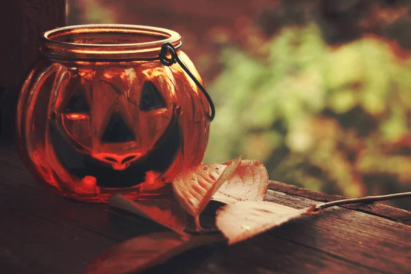 Halloween sütőtök üveg gyertyatartó őszi levelekkel — Stock Fotó