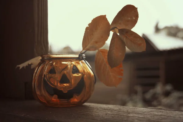 Nevető Halloween sütőtök üveg gyertyatartó őszi levelekkel. — Stock Fotó