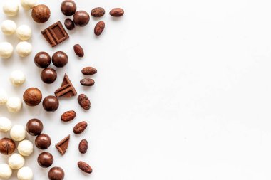 Beyaz masadaki çikolatalı pralinalarla tatlandırılmış çerçeve kopyalama alanı
