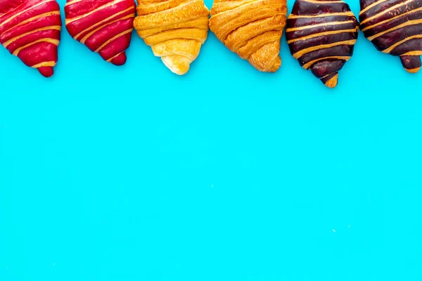 Rahmen von Croissants - frische Backwaren auf blauem Hintergrund. Ansicht von oben — Stockfoto
