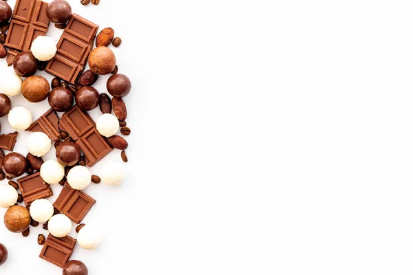 Candy pozadí s čokoládou na bílém stole horní pohled rám. Koncept sladkých zákusků. Mezera pro text — Stock fotografie
