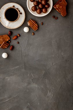 Çikolata ve kahve arkaplanlı, gri masa üstü çerçeveli. Hamur işi, şekerleme konsepti. Boşluğu kopyala