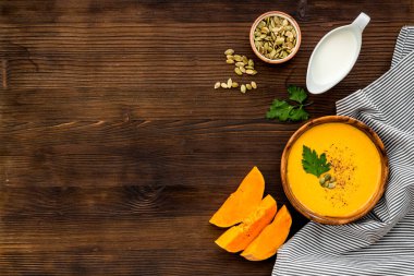 Balkabağı çorbası - maydanozlu ve tohumlu - ahşap arka planda metin için üst görünüm alanı