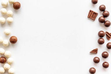 Beyaz masadaki çikolatalı pralinalarla tatlandırılmış çerçeve kopyalama alanı