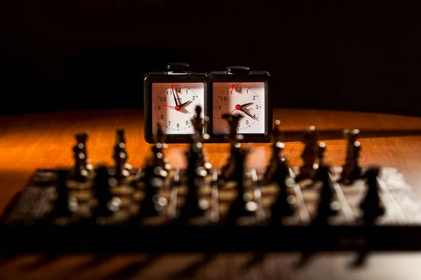 Träschackbräda med klocka på bord — Stockfoto