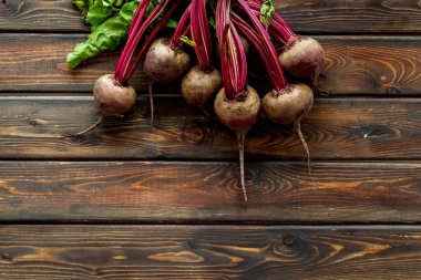 Yeşil kapaklı organik pancar kökleri ve ahşap masasında yapraklar. Üst görünüm