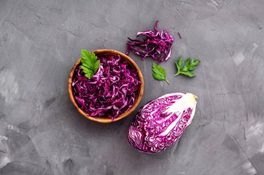 Kırmızı lahana - kesilmiş kafa ve dilimlenmiş - gri mutfak masasının üstünde.