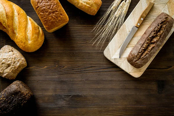 Set de diferentes panes con espiga de trigo sobre mesa de madera. Vista superior —  Fotos de Stock