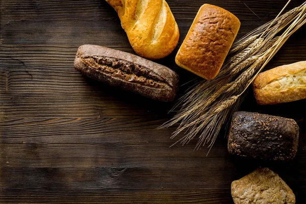 Set of different bread with wheat ear on wooden table. Top view — Stock Photo, Image