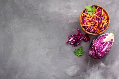 Sağlıklı vejetaryen salatası ve gri mutfak masasının üstünde kırmızı lahana.