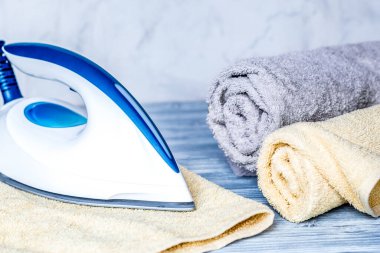 Çamaşır seti, havlular ve gri arka planda ütü.