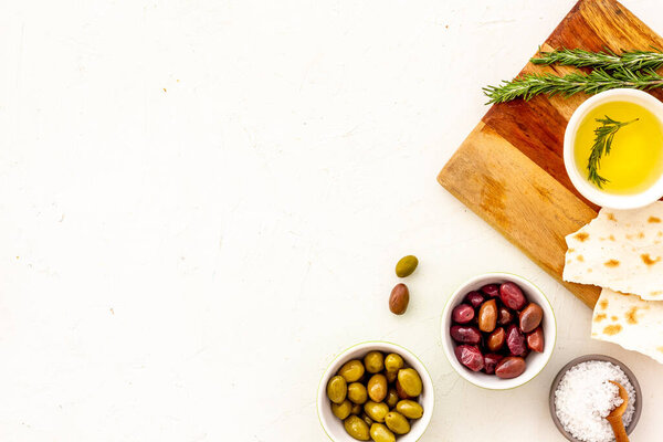 Средиземноморские оливки рядом с хлебом на разделочной доске