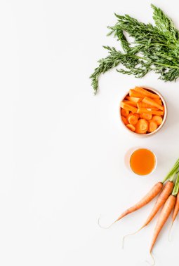 Dilimlenmiş havuç ve meyve suyu beyaz masanın üstünde fotokopi alanı