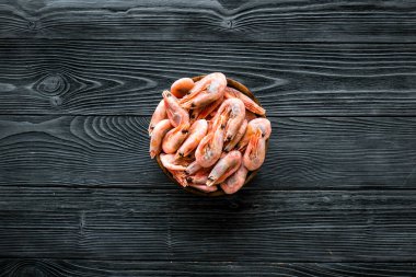 Kabuktaki karidesler koyu ahşap arka planda üstten alta