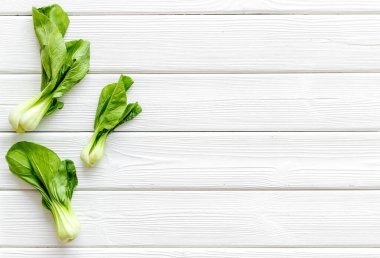 Bok choy hasadı beyaz ahşap arka planda tepeden tırnağa kopyalama alanı