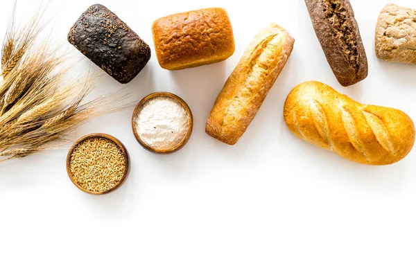 Top view of different loaves of bread and wheat ears copy space — Stock Photo, Image