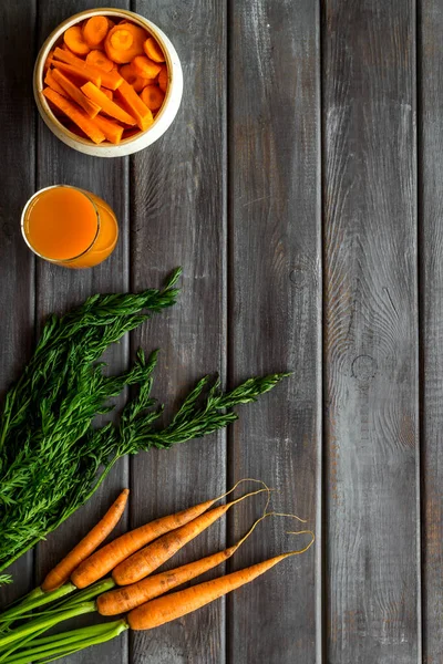 Carrot slices, fresh juice, vegetable with green tops top view copy space