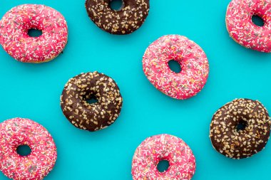 Renkli çörek desenli üst manzara. Çilekli ve çikolatalı çörek.