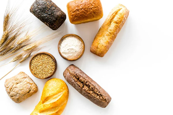 Top view of different loaves of bread and wheat ears copy space — Stock Photo, Image