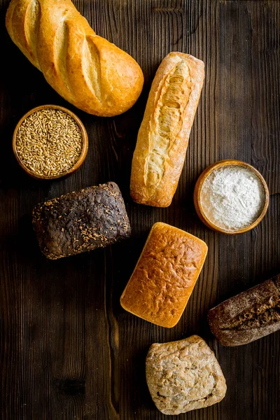 Bakery. Fresh bread in assortment on wooden table top-down — Stock Photo, Image