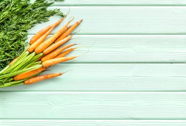 Fotokopi alanının üzerinde yeşil başlıklı taze havuçlar var.