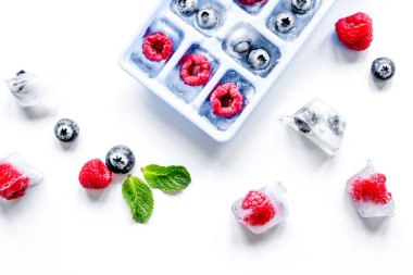 Böğürtlenli buz tepsisi ve beyaz arka plan manzaralı nane.