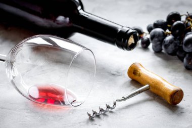 Şarap şişesi ve arka planda üzüm olan restoran seti.