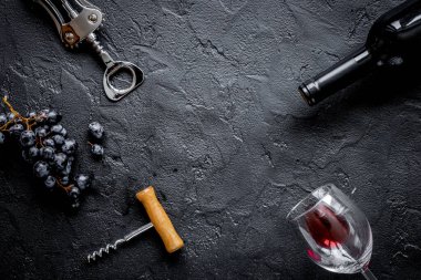 Kırmızı şarap şişesi. Arka planda gözlük var. Üst görünümde maket.