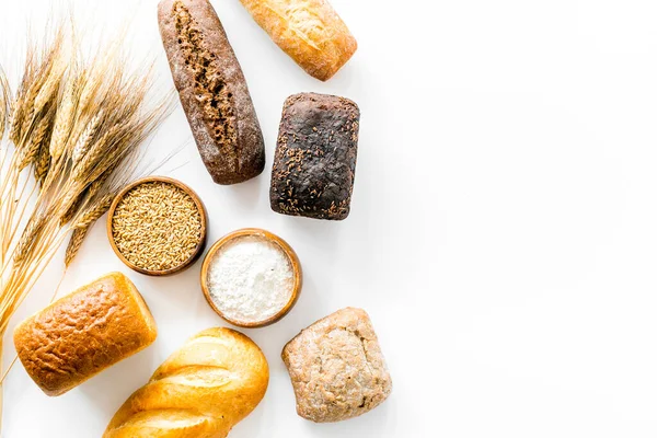 Bread near wheat ears and bowl of flour top-down space for text — Stock Photo, Image
