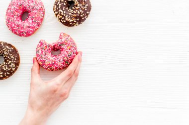Kremalı ve şekerli donutla el ele tutuşmak. Düz yatış, üst görünüm
