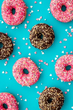 Renkli çörekler pembe ve çikolatalı krema. Fırının düz yatağı, yukarısı manzaralı.