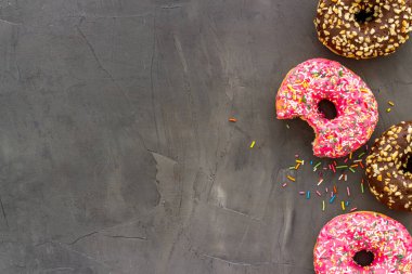 Renkli çörekler pembe ve çikolatalı krema. Fırının düz yatağı, yukarısı manzaralı.