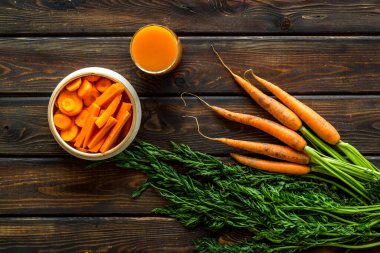 Tahta masa manzaralı dilimlenmiş havuç ve meyve suyu.