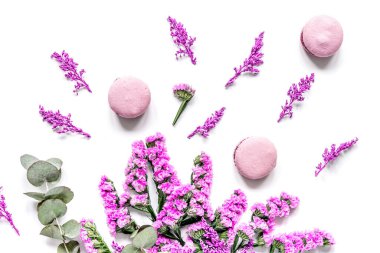 Bahar kadını kahvaltısı, badem kurabiyesi ve çiçeklerle beyaz arka plan manzaralı.