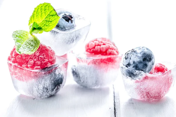 Cubes of berry ice and mint leaf on wooden table beckground — Stock Photo, Image