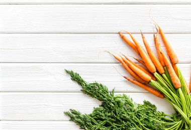 Fotokopi alanının üzerinde yeşil başlıklı taze havuçlar var.