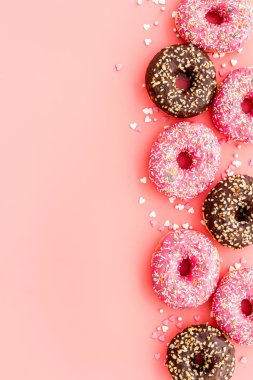 Pembe arka planda düz çörekler, üst görünüm