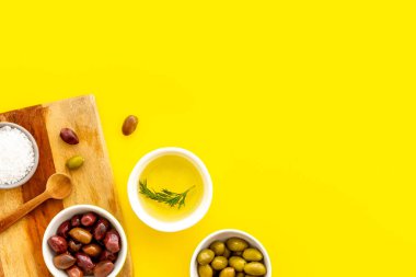 Sarı üst görünüm fotokopi alanındaki tahtayı kesen kaplarda zeytin ve zeytin yağı.