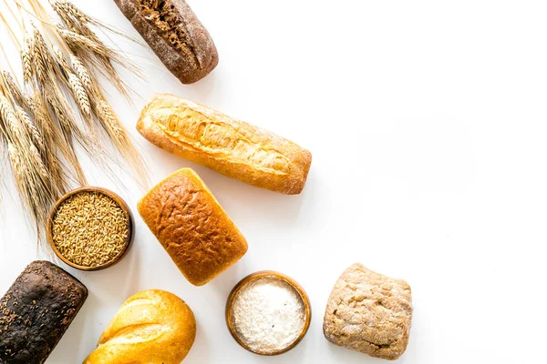 Bakery. Fresh bread in assortment on white table top-down copy space — Stock Photo, Image