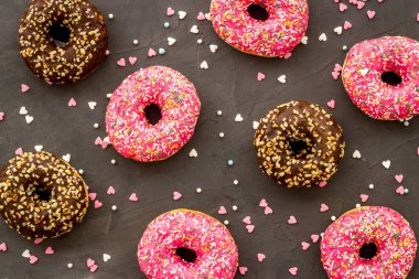 Renkli çörekler pembe ve çikolatalı krema. Fırının düz yatağı, yukarısı manzaralı.